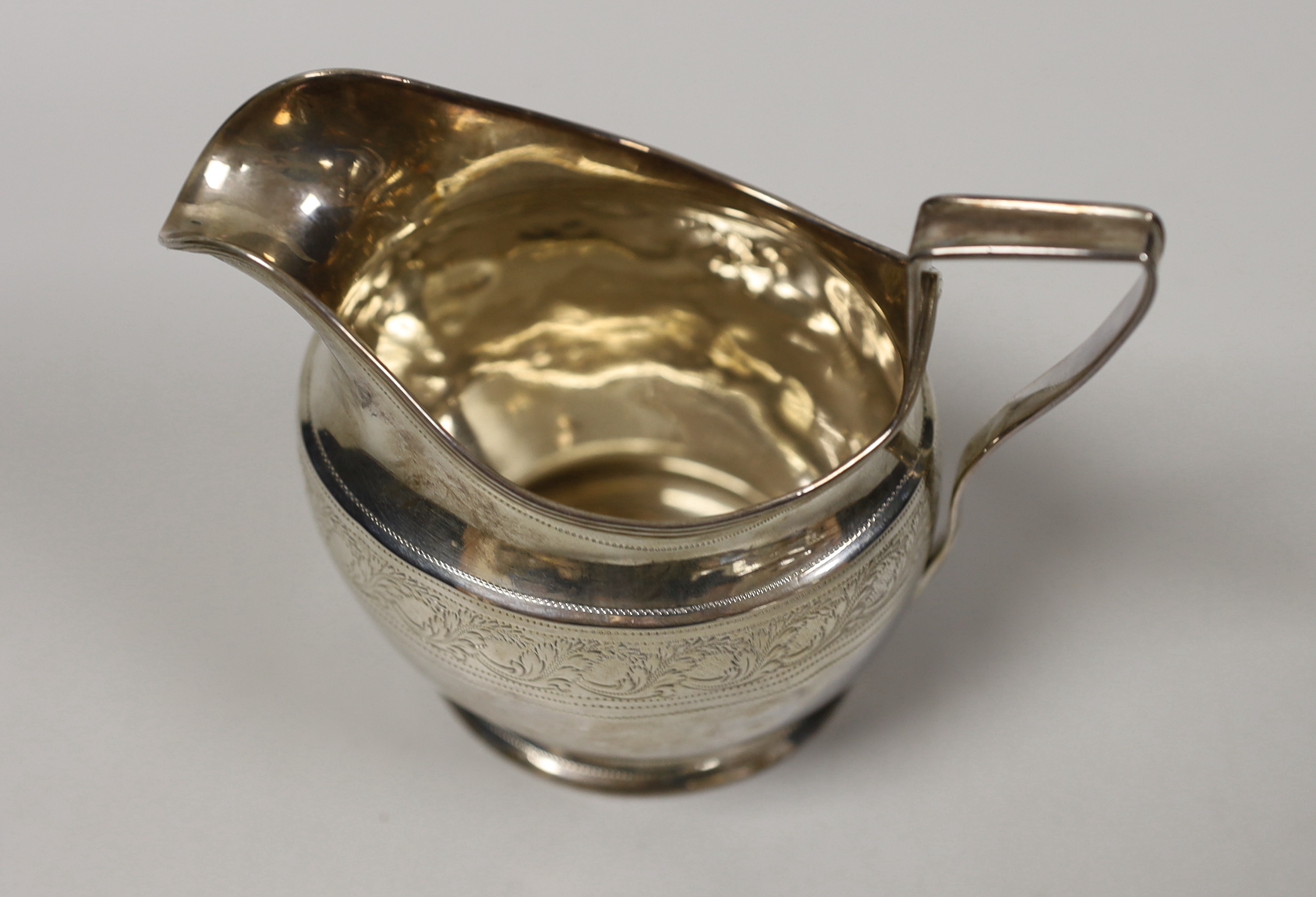 A George III engraved silver helmet shaped cream jug, Andrew Fogelburg, London, 1801, height 10.2cm, 4.7oz.